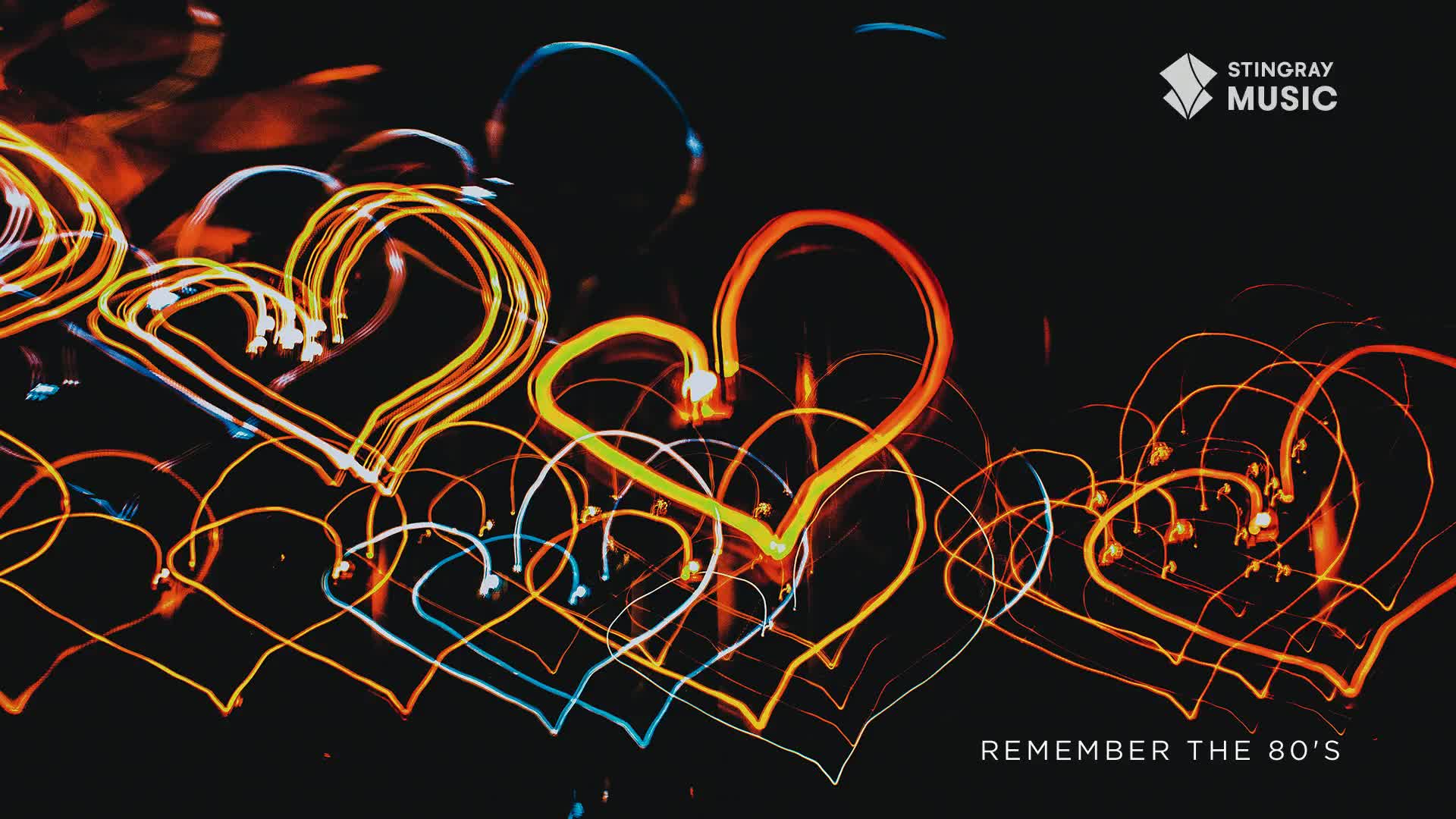 Glowing, heart-shaped light trails weave across a dark background, creating a vibrant, nostalgic feel. The warm yellow and orange hues evoke a sense of the past, like a memory from Stingray Everything '80s.

