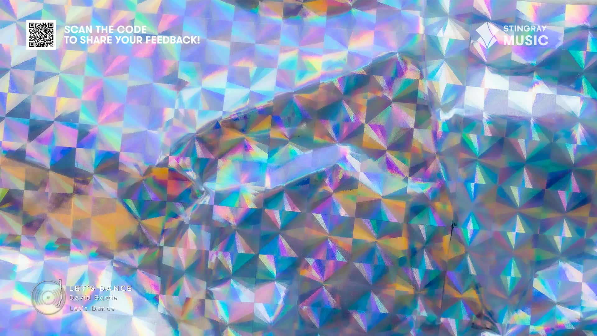 Iridescent foil shimmers, reflecting light in a dazzling display of blues, greens, and yellows. The Stingray Music logo is visible, and the whole scene has a retro, 80s vibe.
