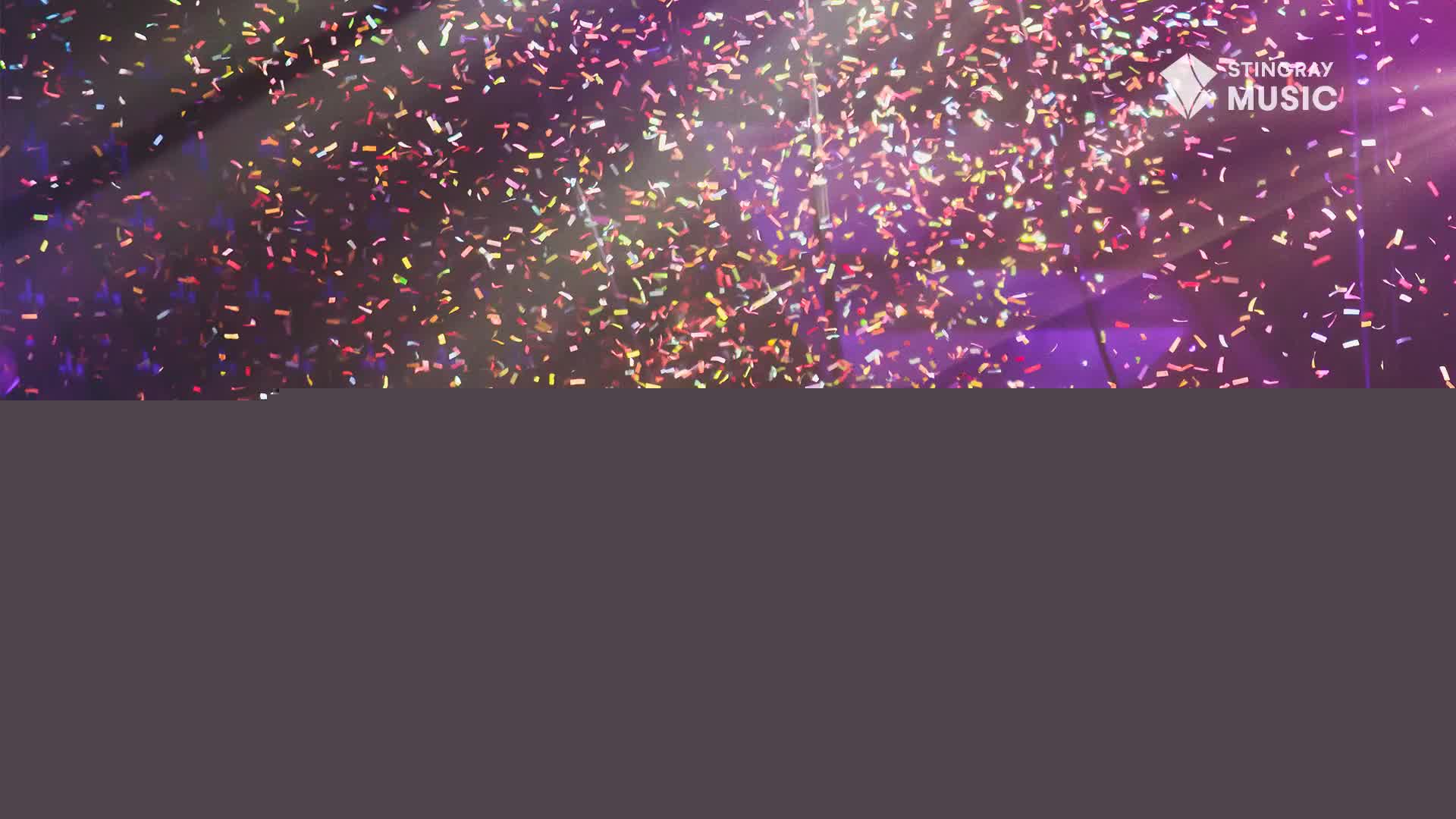 Confetti, shimmering in the spotlights, rains down over a purple-lit stage. The Stingray Music logo is visible as the air fills with celebratory sparkles.
