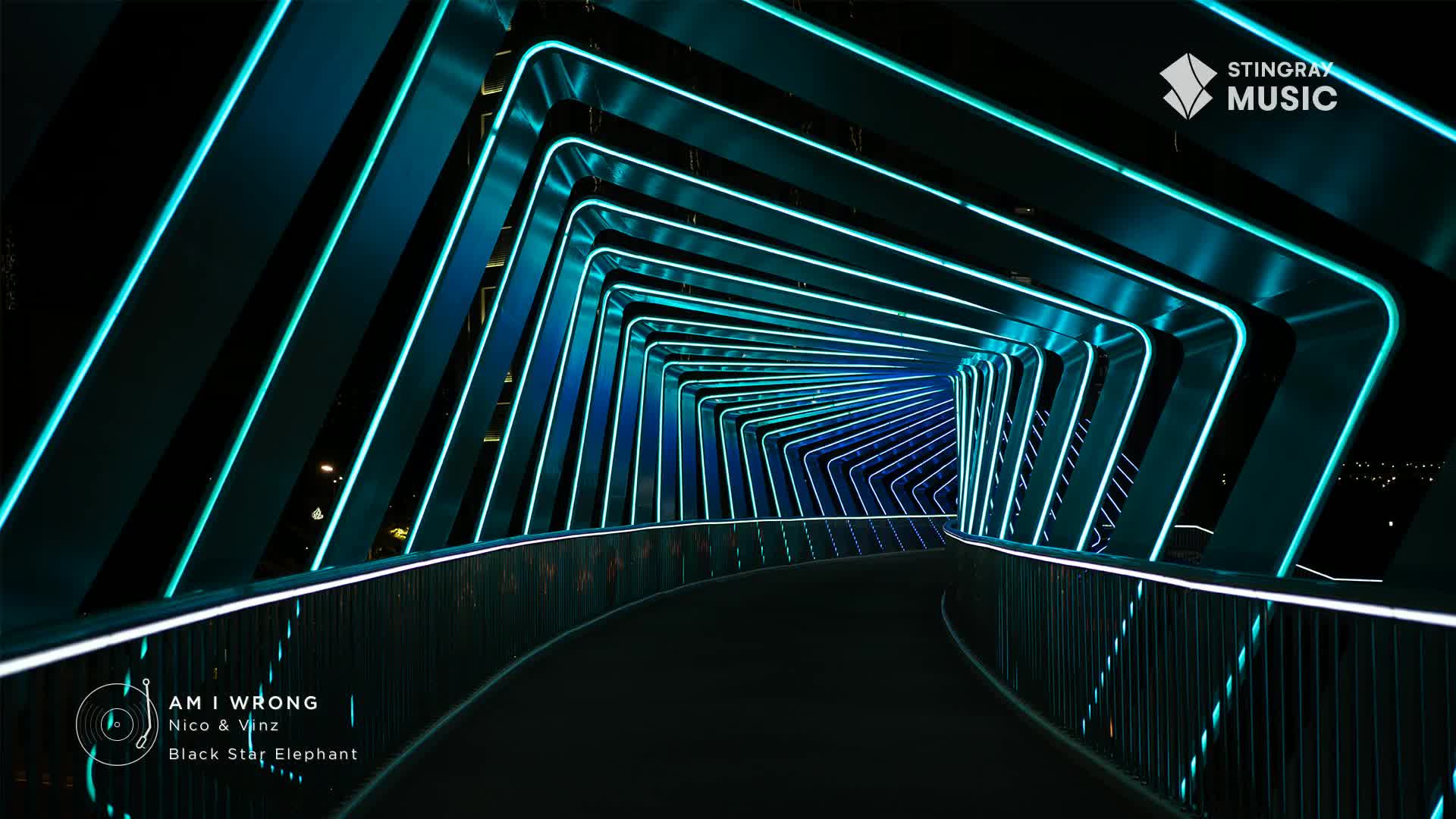 A curved walkway, framed by glowing turquoise lines, stretches into the distance. The Stingray Hit List logo is visible, and the song "Am I Wrong" by Nico & Vinz is playing.

