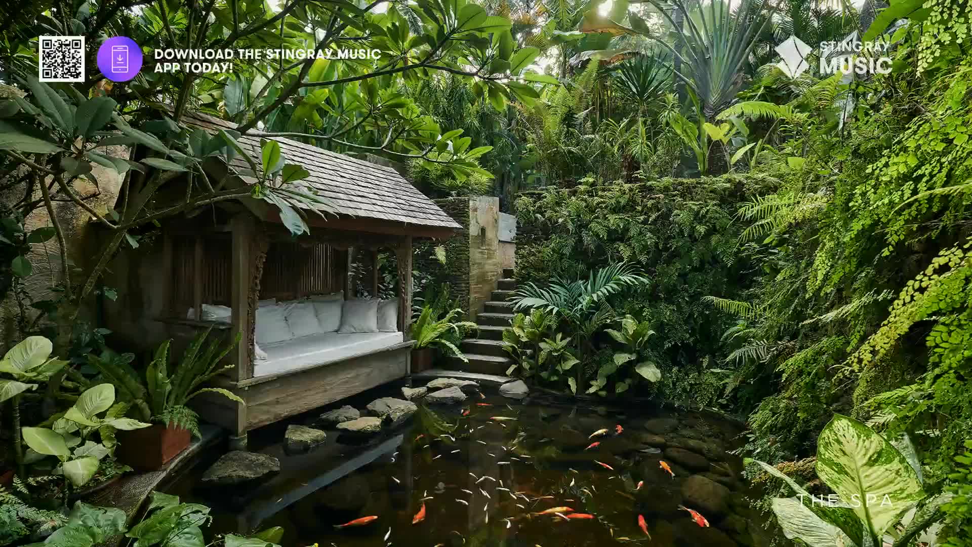 Orange koi swim in the dark water of a pond, their scales catching the dappled sunlight. A wooden pavilion with a thatched roof offers a shaded spot overlooking the tranquil scene.