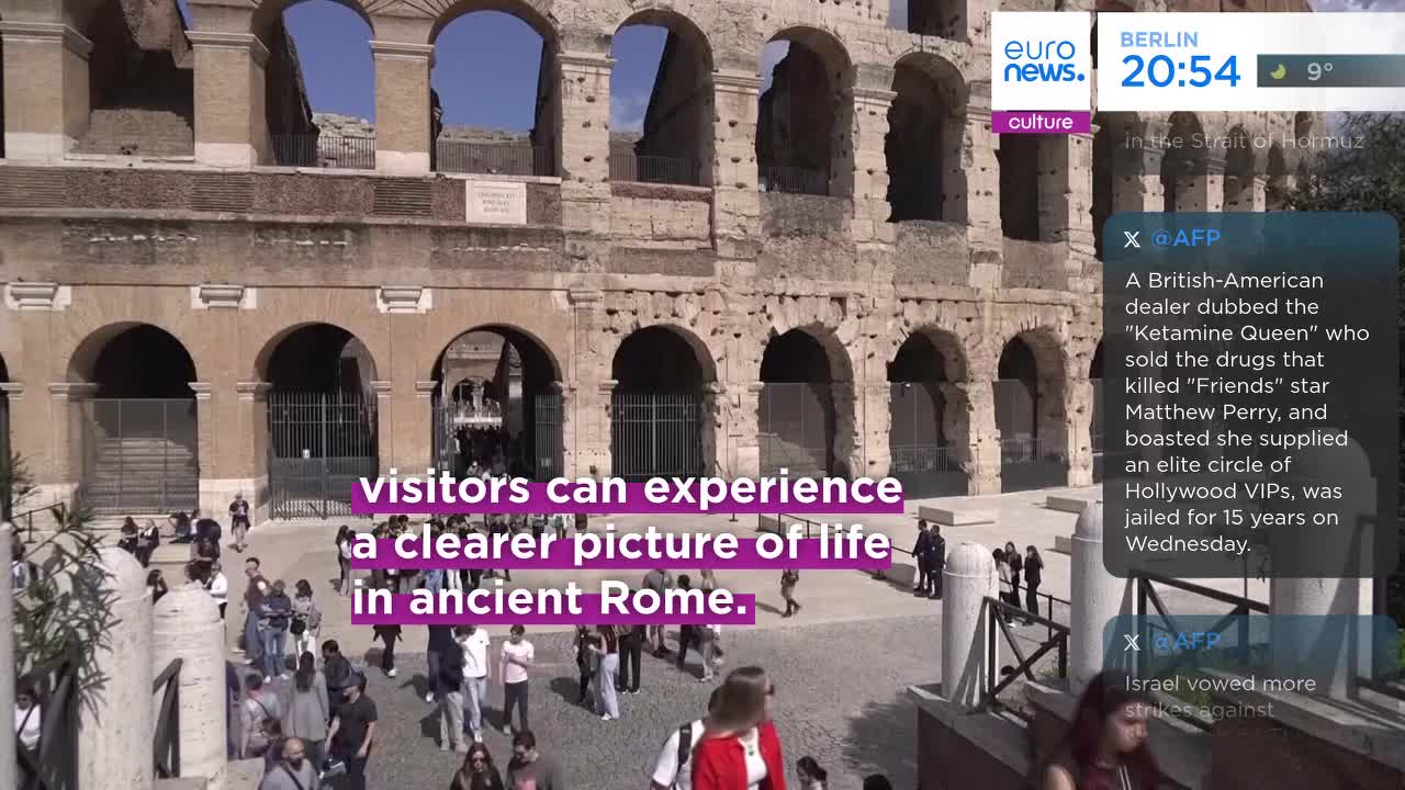 People mill about the ancient Roman amphitheater, the sun warming the weathered stone. A news ticker from Euronews English scrolls by, mentioning a story about a drug dealer and a Hollywood star.