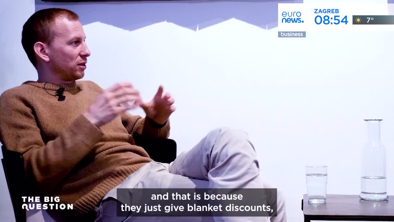 A man in a brown sweater gestures with his hands as he speaks, his words appearing on the screen below. A Euronews graphic indicates it's 8:54 AM in Zagreb, with a temperature of 7 degrees.