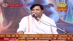 A man in a white shirt and scarf speaks into a microphone, his expression animated. The Aastha Bhajan logo and Hindi text are visible in the background.
A man in a white shirt and scarf speaks into a microphone, his expression animated. The Aastha Bhajan logo and Hindi text are visible in the background.