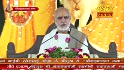 A man, dressed in white, speaks into microphones, a garland around his neck. The Aastha Bhajan logo and Hindi text are visible, suggesting a broadcast from India.
A man, dressed in white, speaks into microphones, a garland around his neck. The Aastha Bhajan logo and Hindi text are visible, suggesting a broadcast from India.