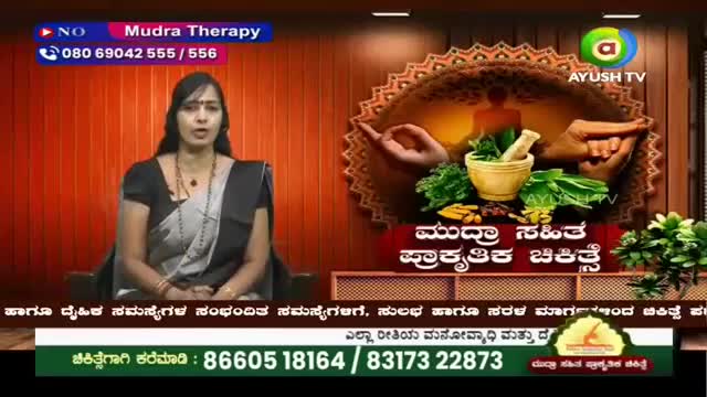 A woman in a sari speaks on Ayush TV, while a graphic behind her displays a mortar and pestle with herbs. Text on the screen announces "Mudra Therapy" and provides contact numbers.