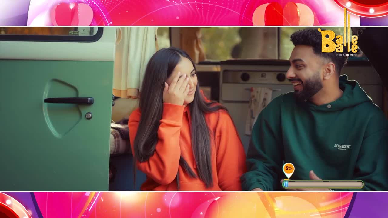 The green van door is open, revealing a young woman in an orange hoodie covering her eyes and a man in a green hoodie beside her. They're both smiling, sharing a lighthearted moment inside what looks like a camper.