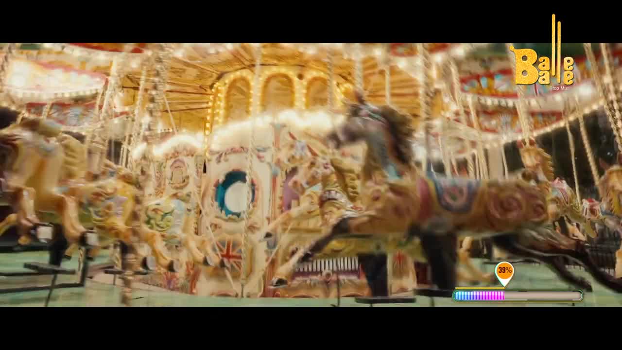 The carousel horses are spinning around, their painted details a blur against the bright lights. A "Balle Balle" logo is visible, hinting at a lively Indian celebration.