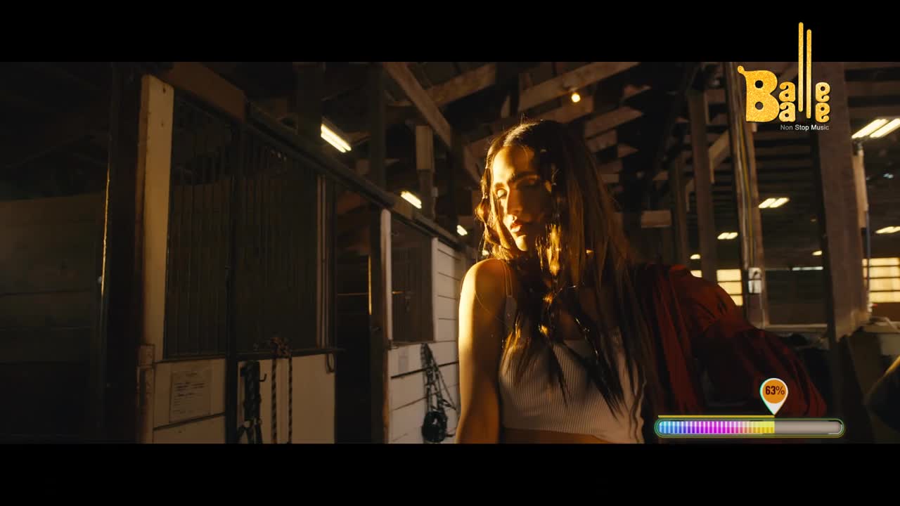 A young woman stands in a dimly lit stable, her face illuminated by a warm glow. The Balle Balle logo, signifying the vibrant Indian music scene, is visible in the upper right corner.