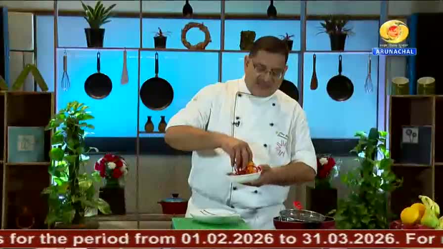 A chef in a white uniform carefully arranges small red pieces on a white plate. This cooking demonstration is airing on DD Arun Prabha, a channel from India.