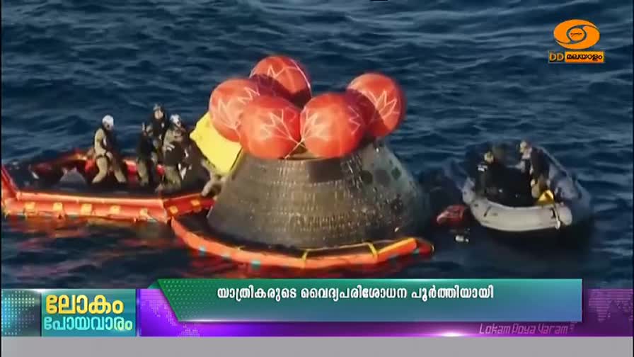 A capsule, topped with bright orange flotation bags, bobs in the ocean. Rescue boats surround it, their crews preparing to secure the craft.