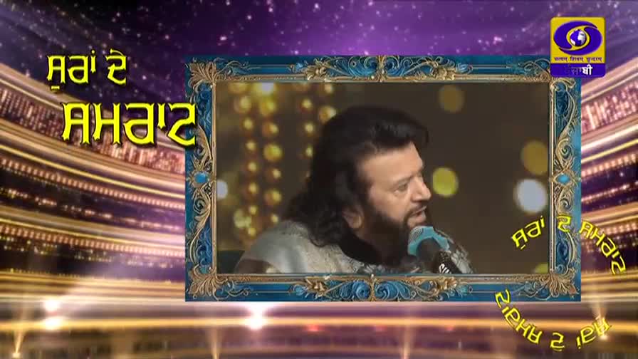 A man with long, dark hair and a beard speaks into a microphone, framed by an ornate border. Yellow Punjabi text, "Raja De Raja," appears on the screen, along with the DD Punjabi logo.