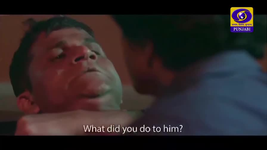 A man's face is held close, his eyes wide with a mixture of fear and confusion. Another person's shoulder is visible, leaning in as they speak the question, "What did you do to him?" A man's face is held close, his eyes wide with a mixture of fear and confusion. Another person's shoulder is visible, leaning in as they speak the question, "What did you do to him?"