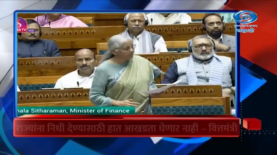 The Finance Minister stands at a podium, addressing a room of seated officials. A DD Sahyadri graphic overlays the scene, identifying her and the broadcast.