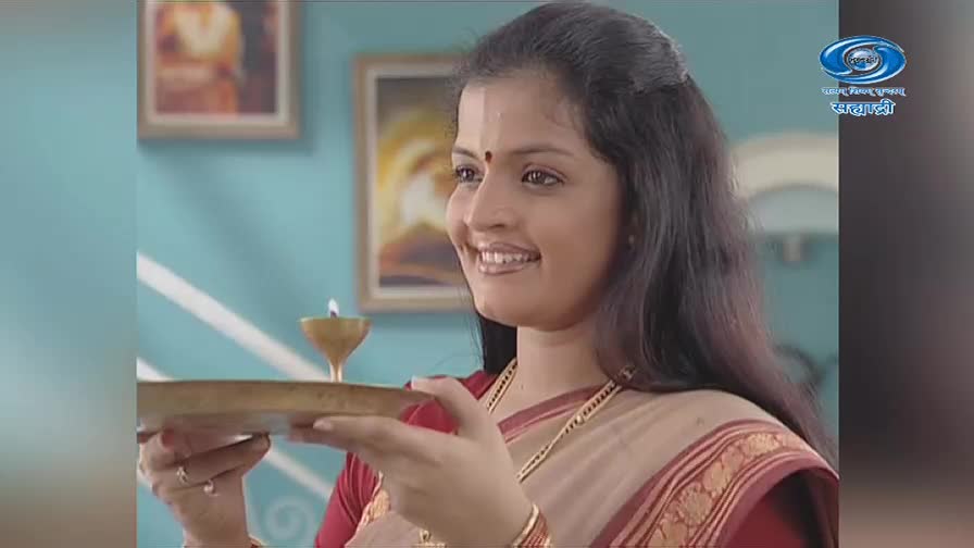 A woman smiles, holding a brass plate with a lit diya. The DD Sahyadri logo appears in the corner, indicating this is likely from a Marathi program.