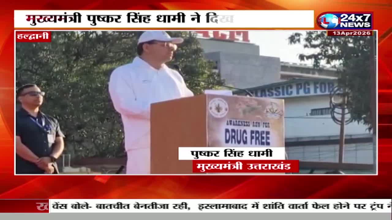 The Chief Minister of Uttarakhand, Pushkar Singh Dhami, stands at a podium speaking to a crowd. A banner behind him reads "Awareness Day for Drug Free."