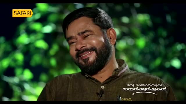 A man with a beard laughs heartily, his eyes crinkled. The Safari TV logo is visible in the corner.