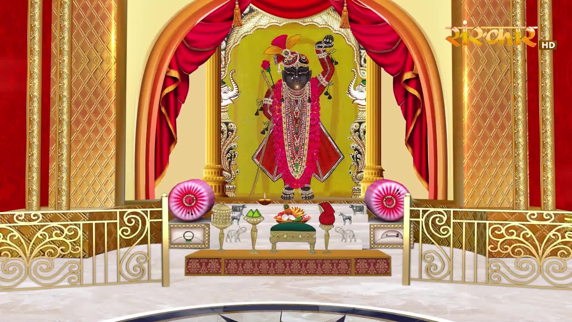A dark, ornate deity stands on a raised platform, adorned in vibrant pink robes and a jeweled headdress. Sanskar TV's logo appears in the upper right corner, hinting at a broadcast from India.