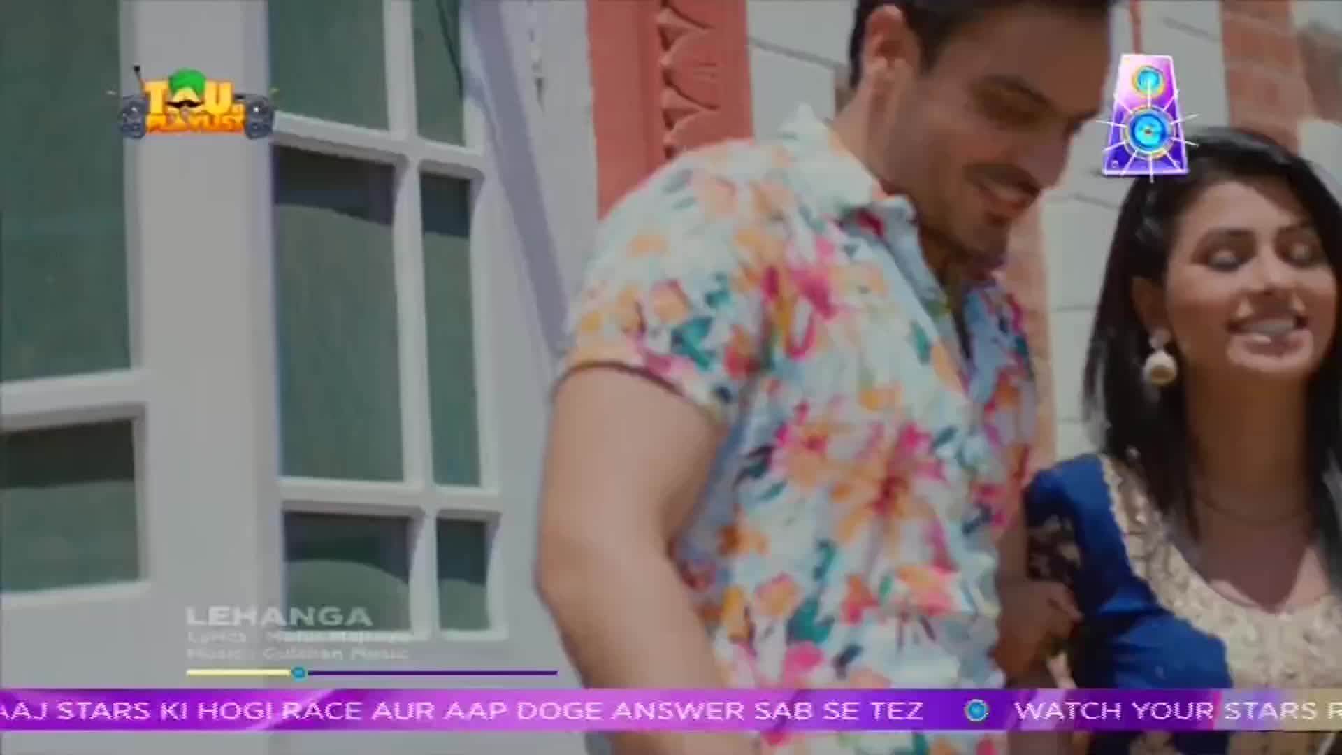 A man in a floral shirt smiles, looking down at a woman in a blue and gold outfit. The ShowBox logo and song title "Lehanga" are overlaid on the scene.
