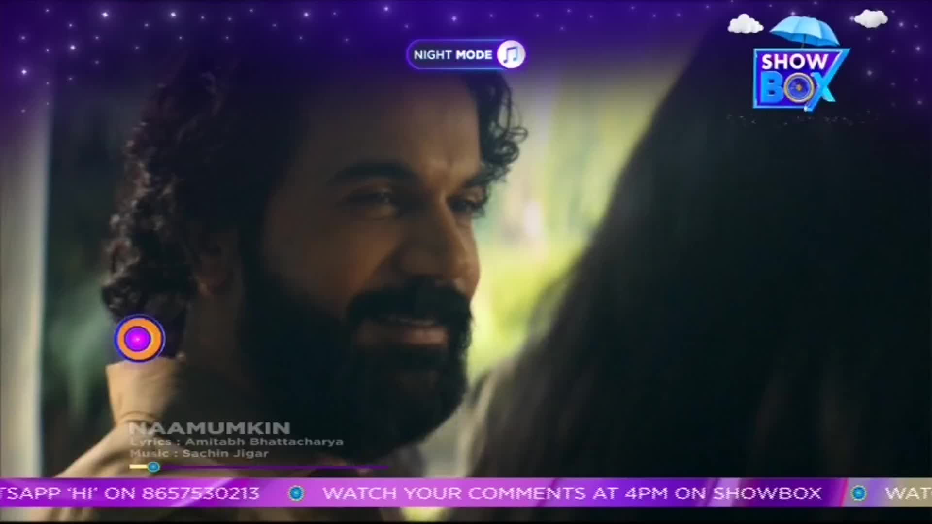 A man with a beard smiles, looking at someone just out of frame. The ShowBox logo sits in the corner, and the song "Naamumkin" is playing.
