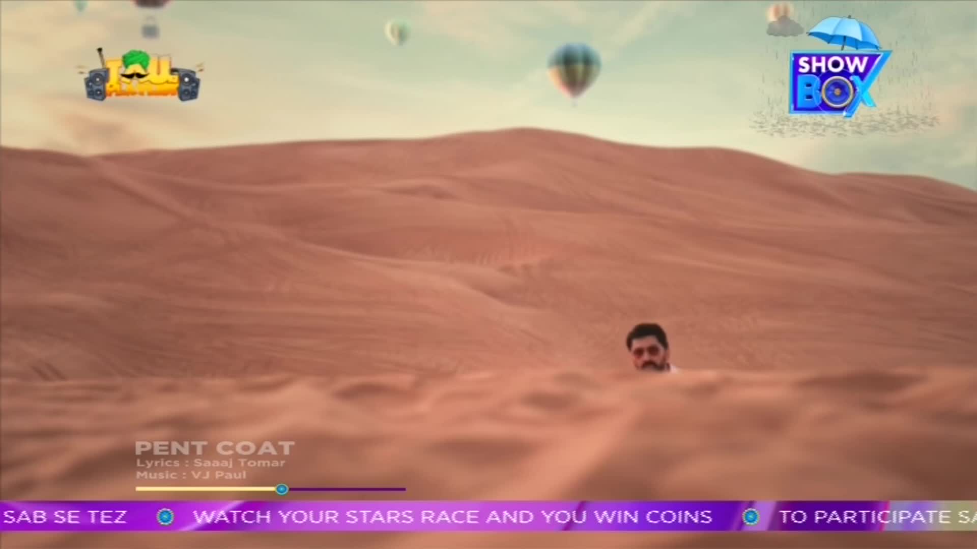 A man with sunglasses peeks out from the sand dunes, while a cartoon vehicle with a mustache floats in the sky. Above, several hot air balloons drift across the horizon, all under the ShowBox logo.
