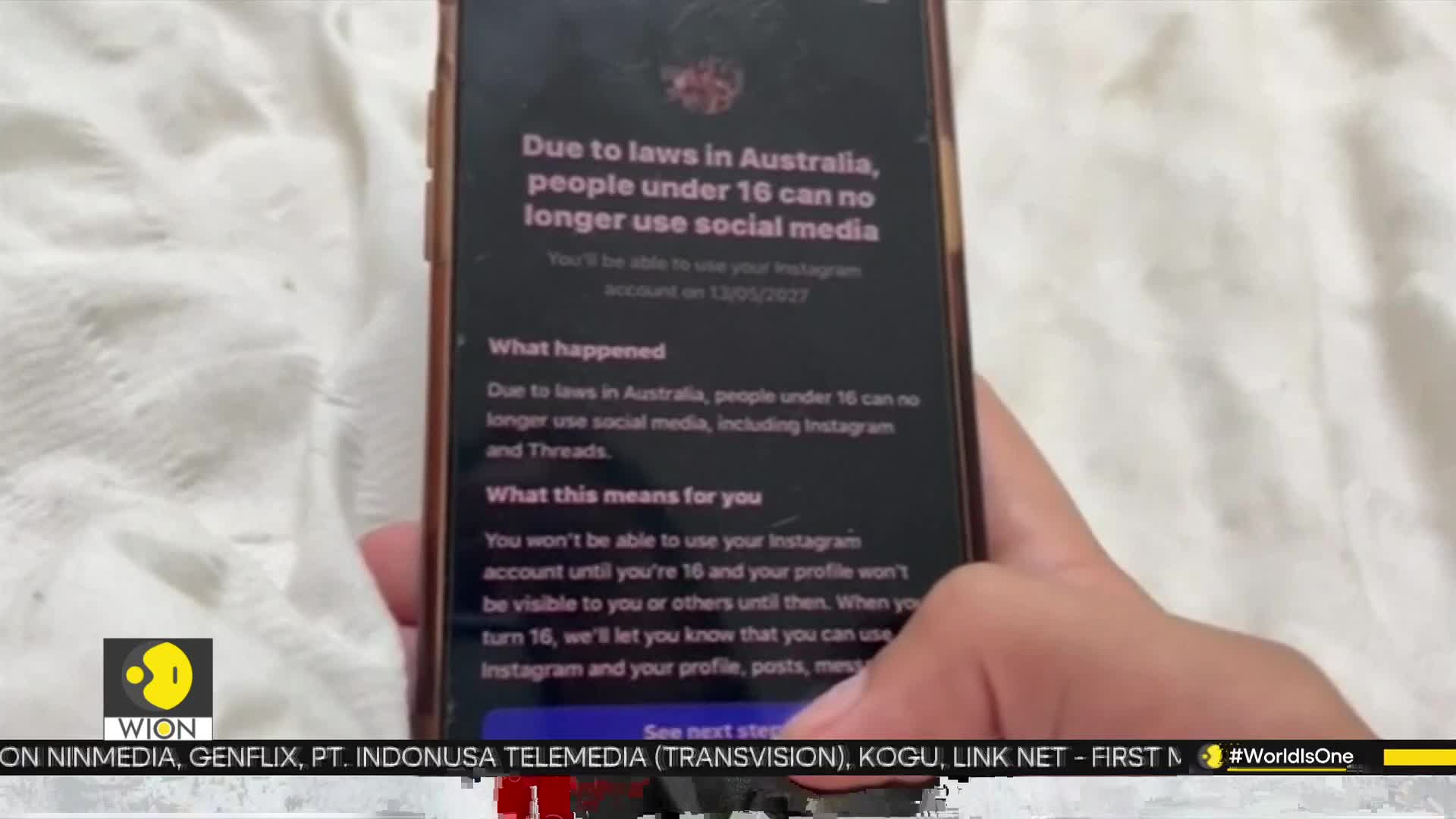 A phone screen displays a message about Australian laws restricting social media use for those under 16. The WION logo is visible in the corner, indicating a news report.