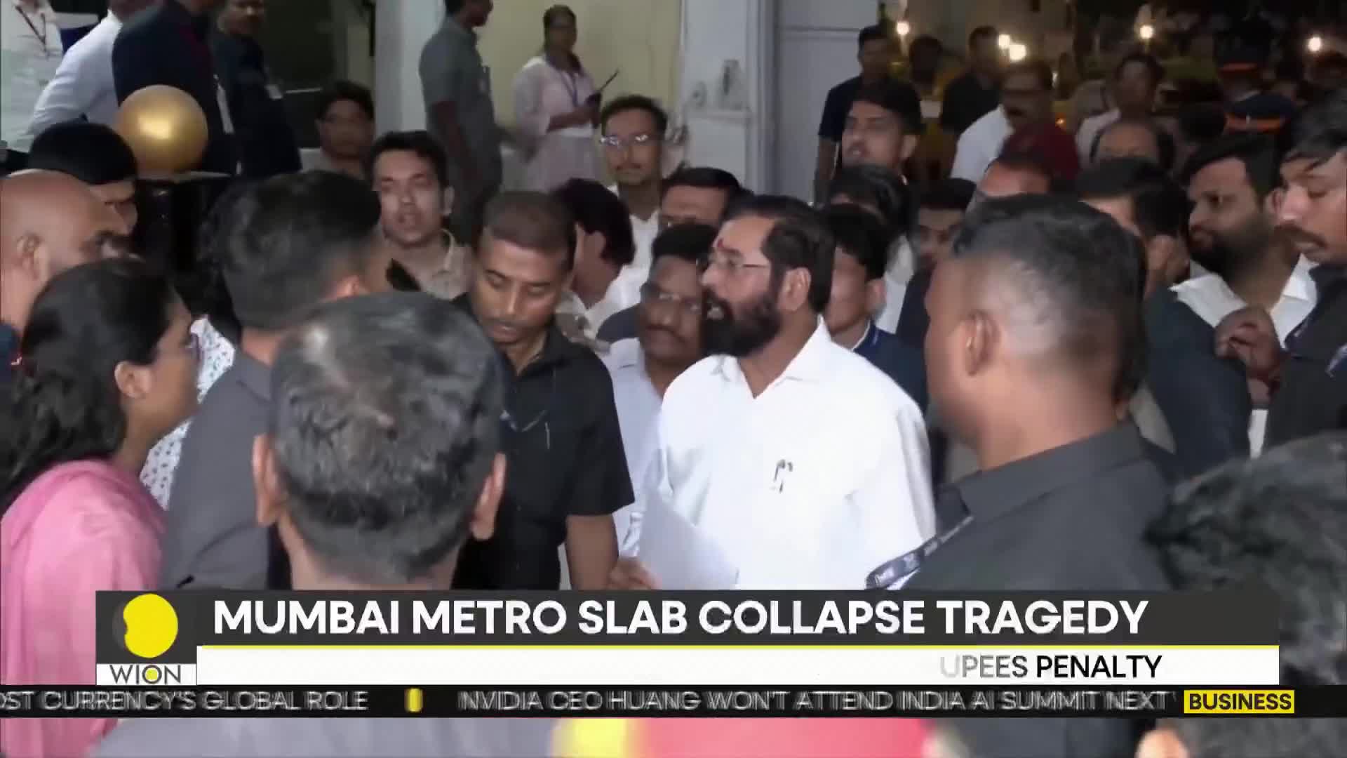 A crowd gathers, their faces turned towards a man in a white shirt. The WION news ticker scrolls below, mentioning a Mumbai Metro slab collapse.