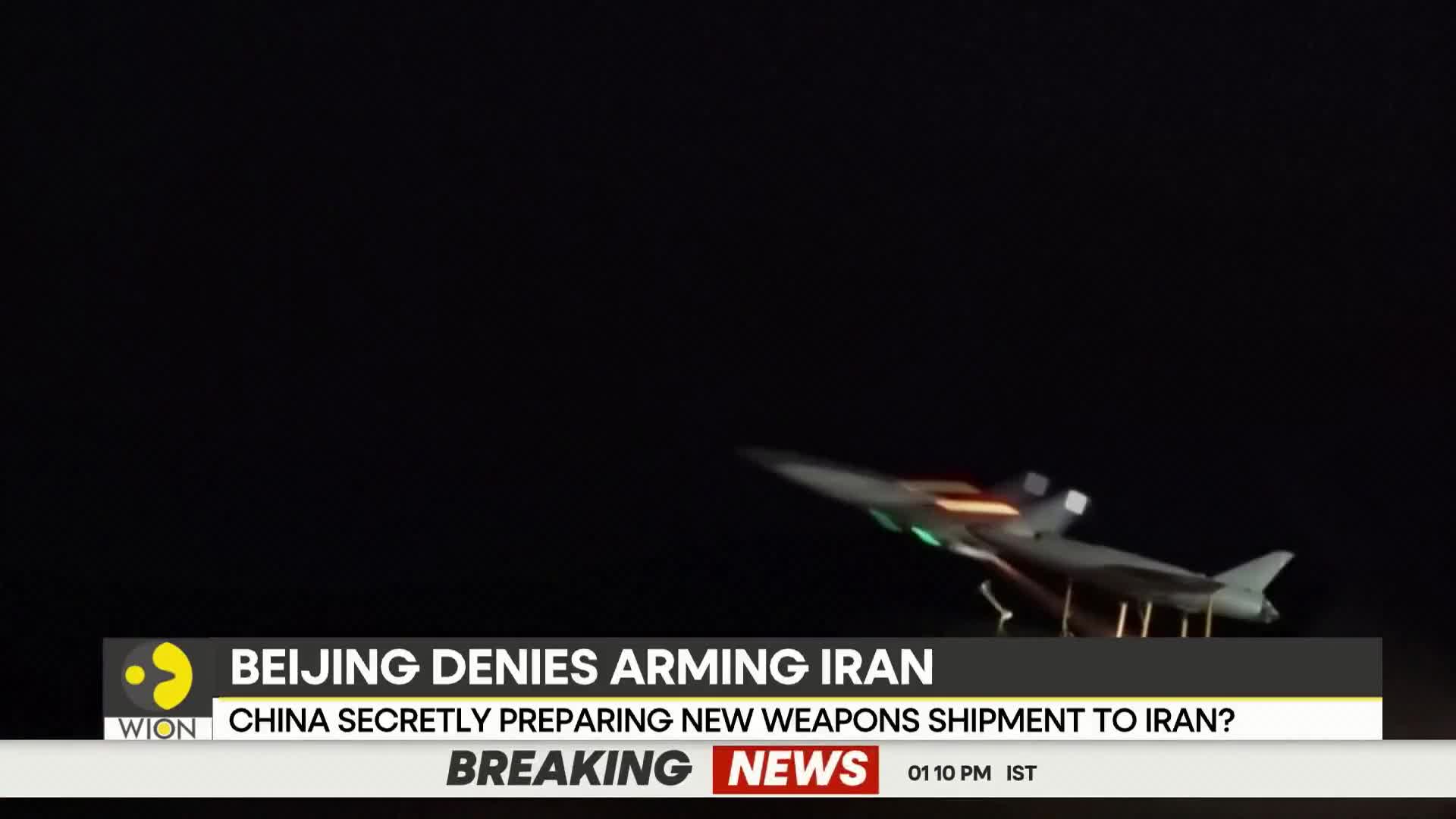 A drone, lit with green and orange lights, is being prepared for launch. This is part of a WION breaking news report about China's alleged arms shipments.