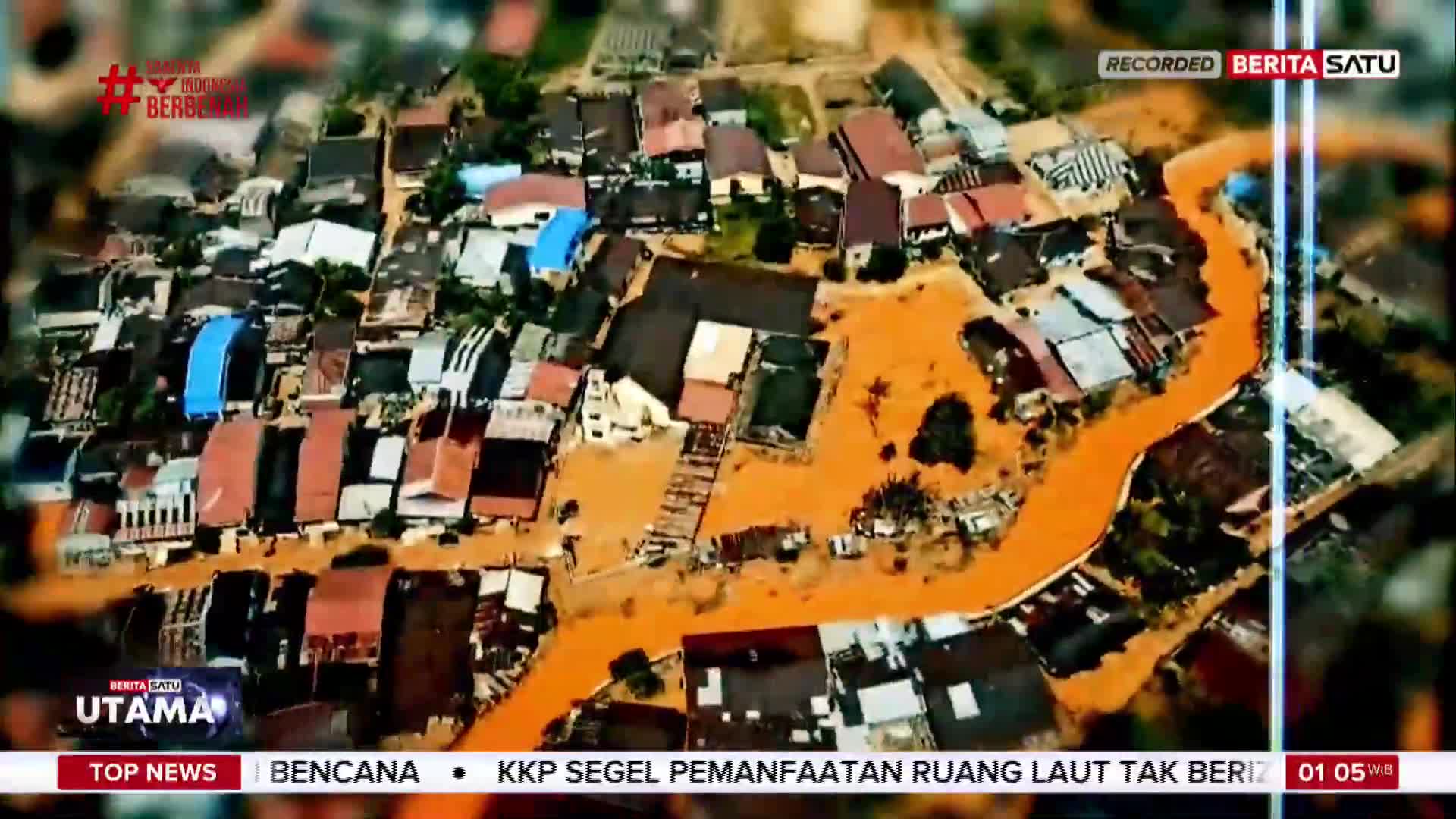 Muddy floodwaters surge through a densely packed Indonesian neighborhood, as reported by BeritaSatu English. The brown water surrounds the buildings, creating a river of destruction.
