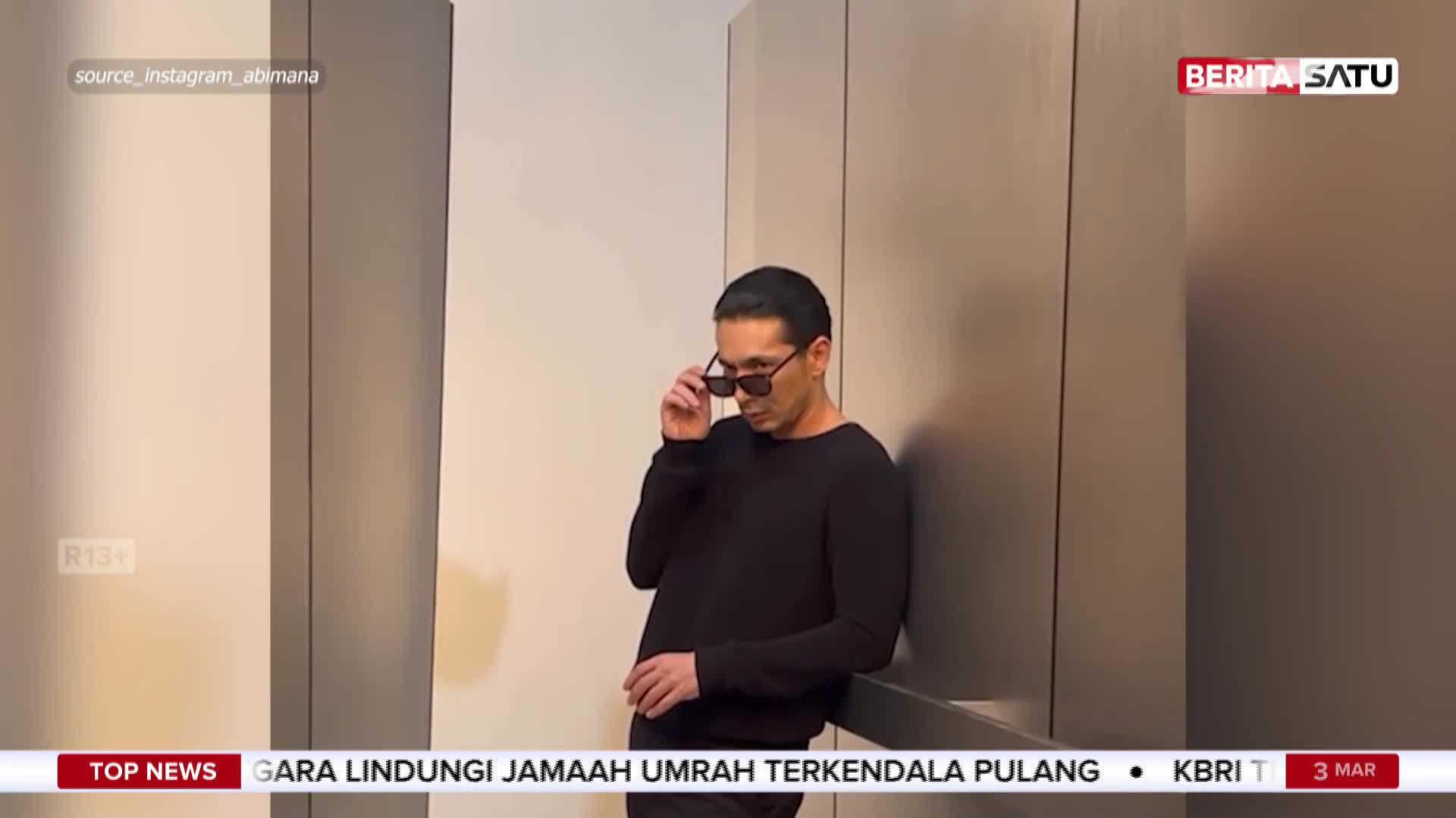A man in a black sweater adjusts his sunglasses, leaning against a textured wall. This scene is part of a BeritaSatu English report from Indonesia. A man in a black sweater adjusts his sunglasses, leaning against a textured wall. This scene is part of a BeritaSatu English report from Indonesia.