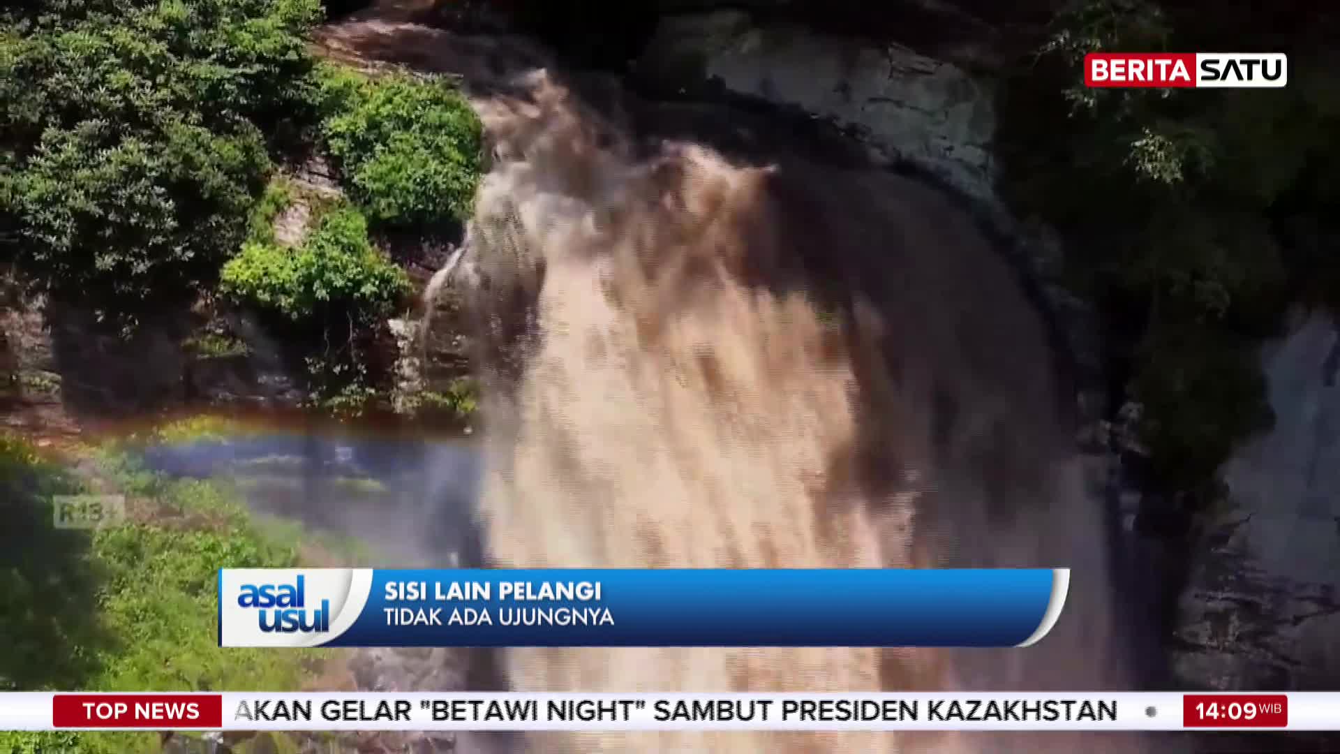 The muddy water cascades down the cliff face, a powerful torrent. A faint rainbow arcs through the mist at the base of the falls. The muddy water cascades down the cliff face, a powerful torrent. A faint rainbow arcs through the mist at the base of the falls.