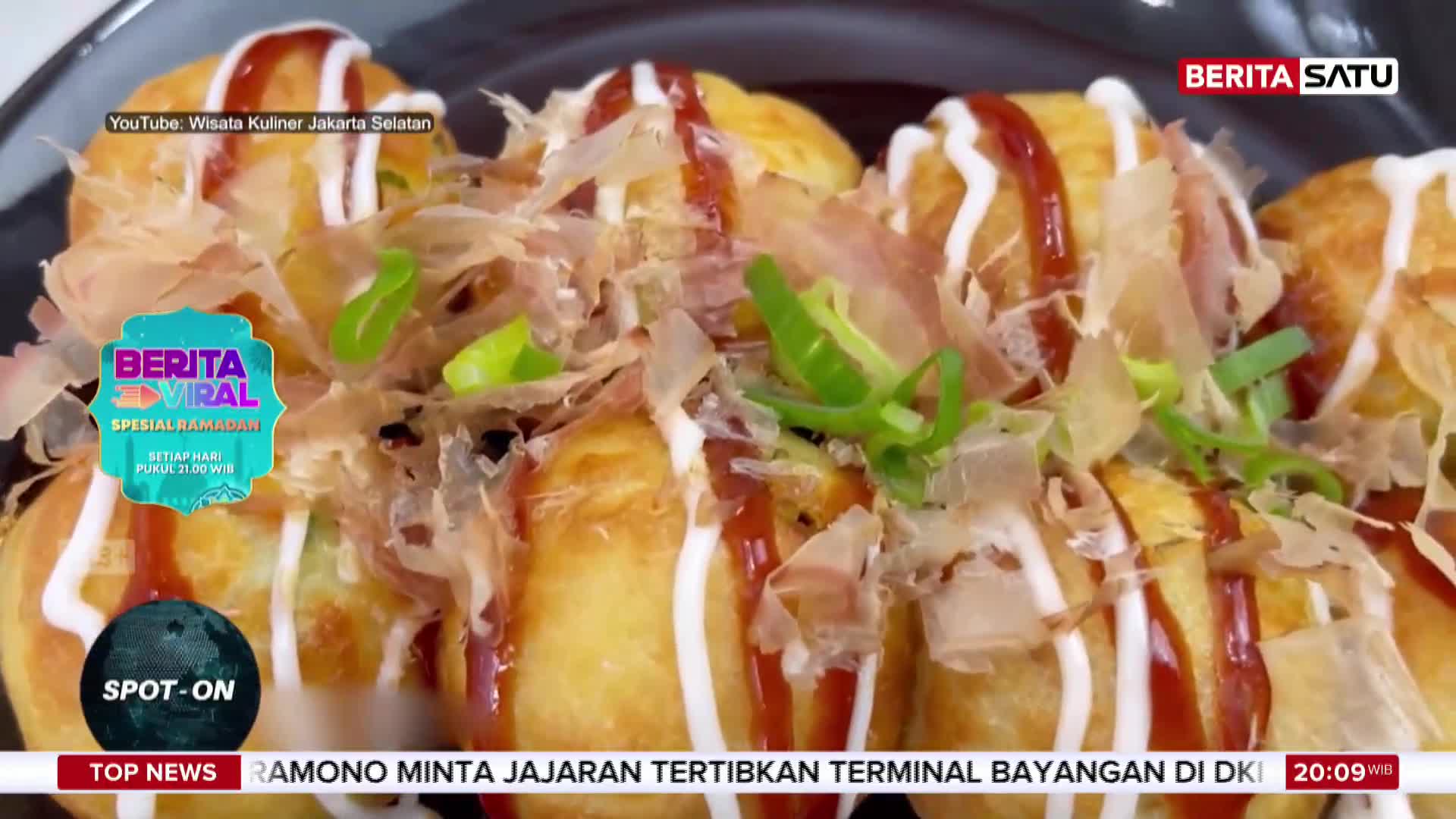 Golden-brown balls, drizzled with white sauce and a reddish glaze, are topped with wispy flakes and green scallions. This dish, featured on BeritaSatu, looks ready to be served.