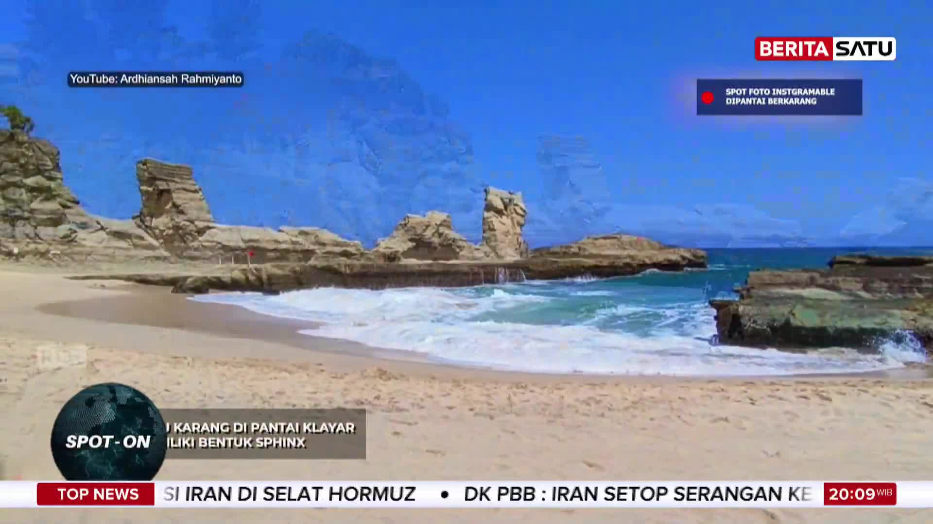Waves crash against the rocky formations jutting out from the shore at Pantai<bos>. The bright Indonesian sun shines down on the sandy beach and turquoise water.