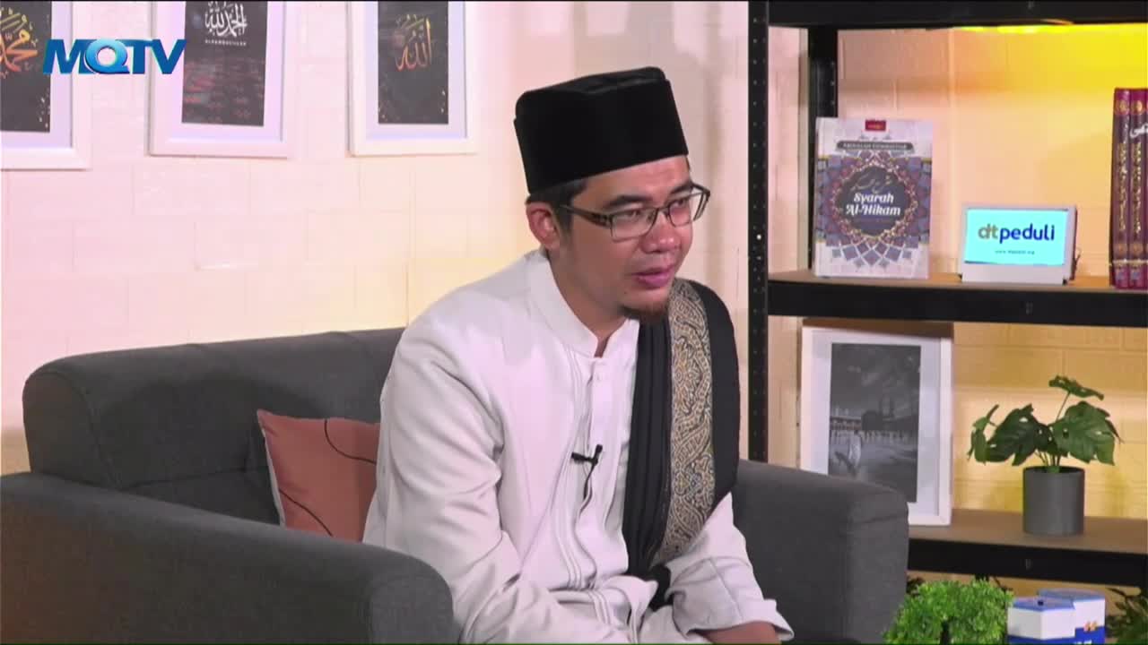 The man in the black cap and glasses is seated on a gray couch, speaking into the camera. Behind him, the MQTV logo is visible, and shelves hold books and a small monitor.
The man in the black cap and glasses is seated on a gray couch, speaking into the camera. Behind him, the MQTV logo is visible, and shelves hold books and a small monitor.