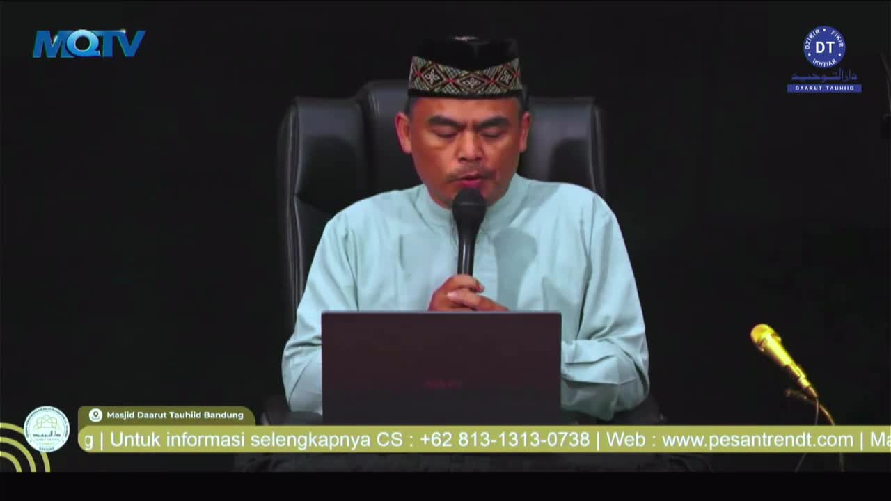 A man in a patterned cap and light blue shirt speaks into a microphone, focused on something unseen. The MQTV logo is visible in the corner, and a laptop sits on the table in front of him.
A man in a patterned cap and light blue shirt speaks into a microphone, focused on something unseen. The MQTV logo is visible in the corner, and a laptop sits on the table in front of him.