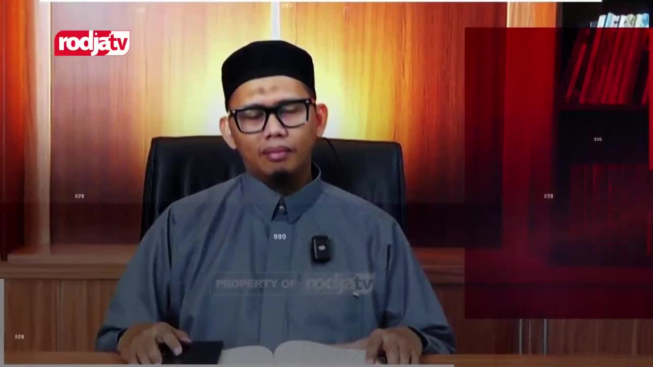 A man in a grey robe and black peci sits at a desk, eyes closed, with a book open before him. The Rodja TV logo appears in the upper left corner of the screen.