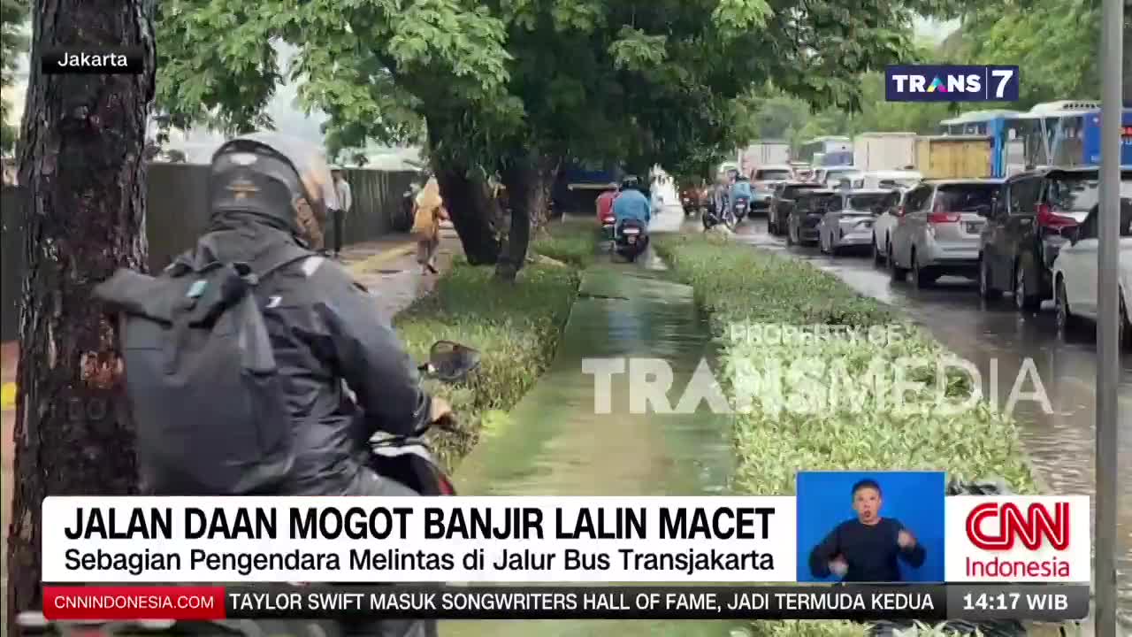 Motorcycles weave through a flooded bus lane as cars are backed up in Jakarta traffic. The rain continues to fall on the already saturated road. Motorcycles weave through a flooded bus lane as cars are backed up in Jakarta traffic. The rain continues to fall on the already saturated road.
