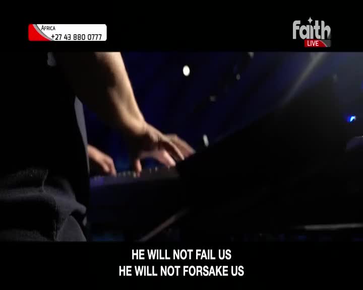 Fingers dance across the keyboard, a steady rhythm filling the dark space. The Faith TV broadcast from South Africa continues with a message of unwavering support.