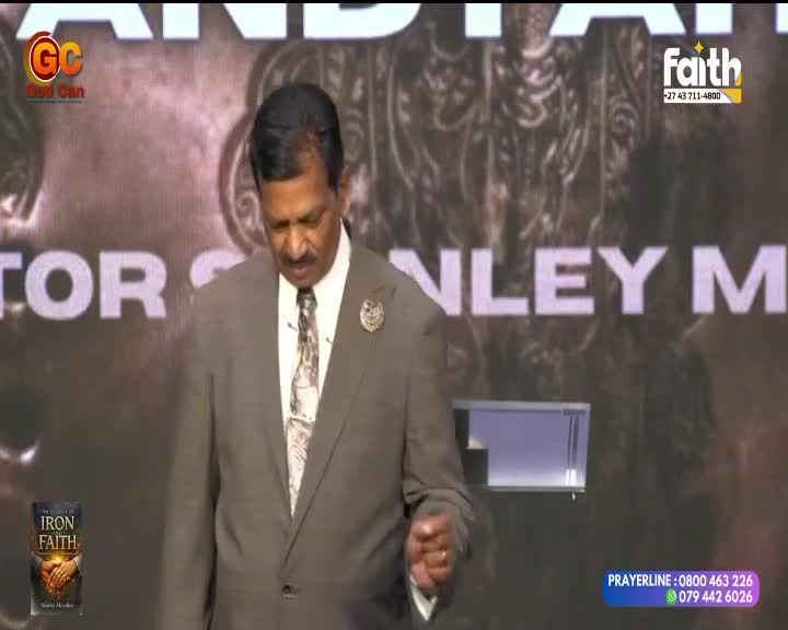 A man in a suit stands on a stage, his head bowed. A graphic for Faith TV is visible in the corner.