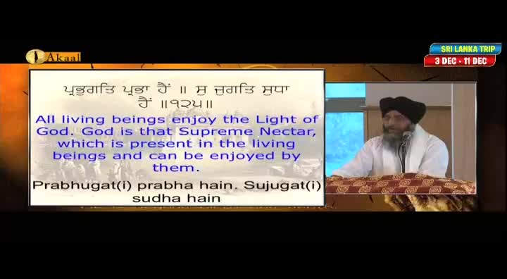 A man in a turban and white robes speaks into a microphone, his words displayed in text on the screen. The Akaal Channel logo is visible, and a banner advertises a trip to Sri Lanka.
