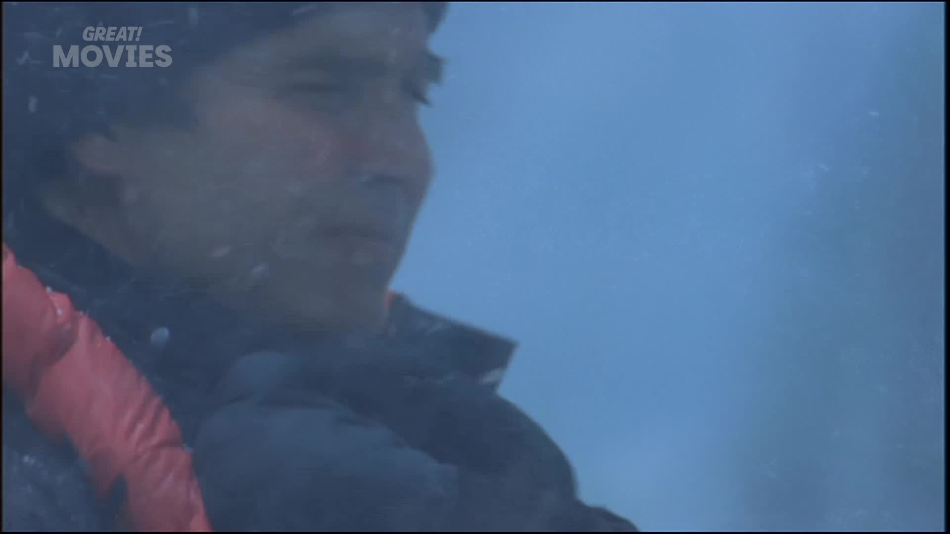 A man's face, framed by a red collar, appears through a misty, blue expanse. The "GREAT! MOVIES" logo is visible in the top left corner.