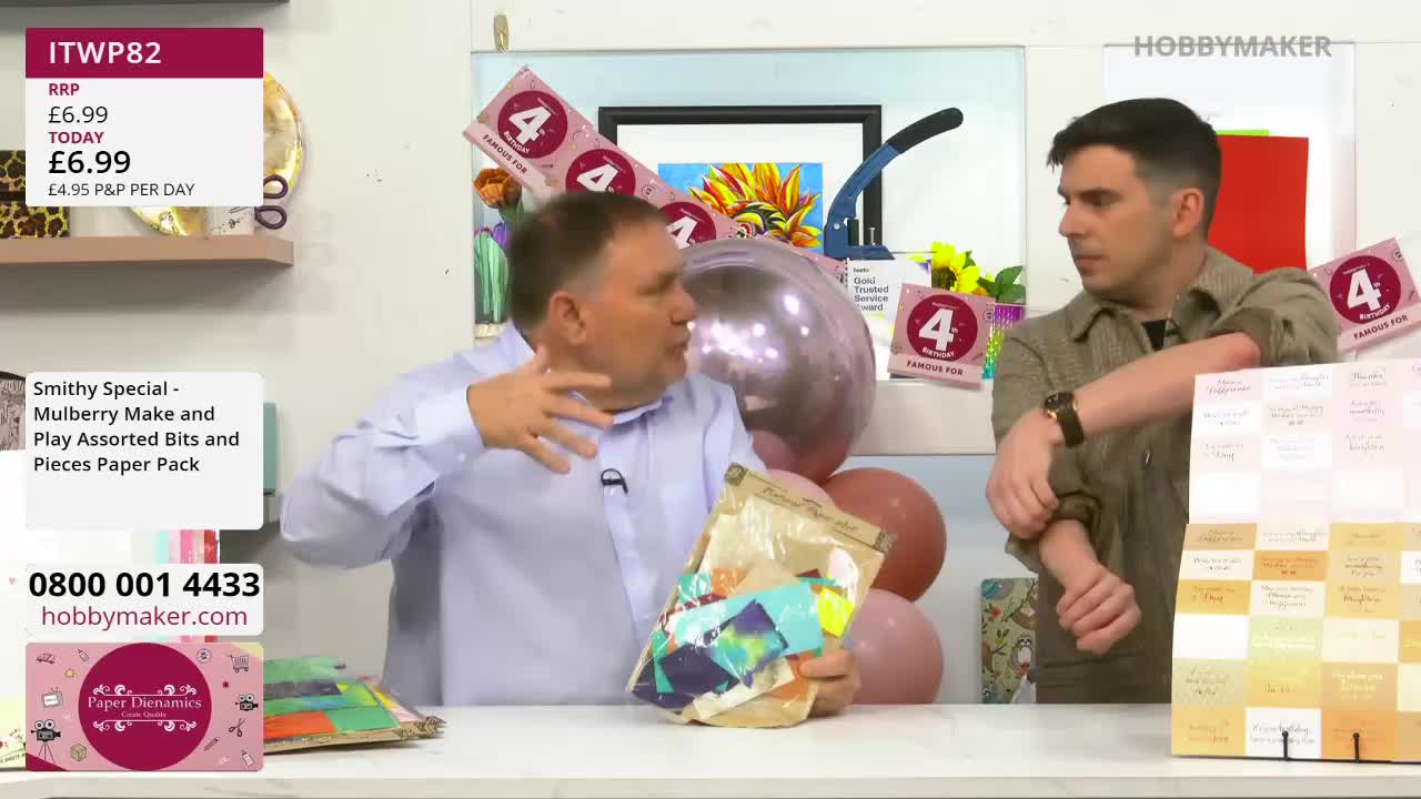 A man gestures enthusiastically, holding up a clear bag filled with colourful paper scraps. Beside him, another man adjusts his sleeve as he looks on. A man gestures enthusiastically, holding up a clear bag filled with colourful paper scraps. Beside him, another man adjusts his sleeve as he looks on.