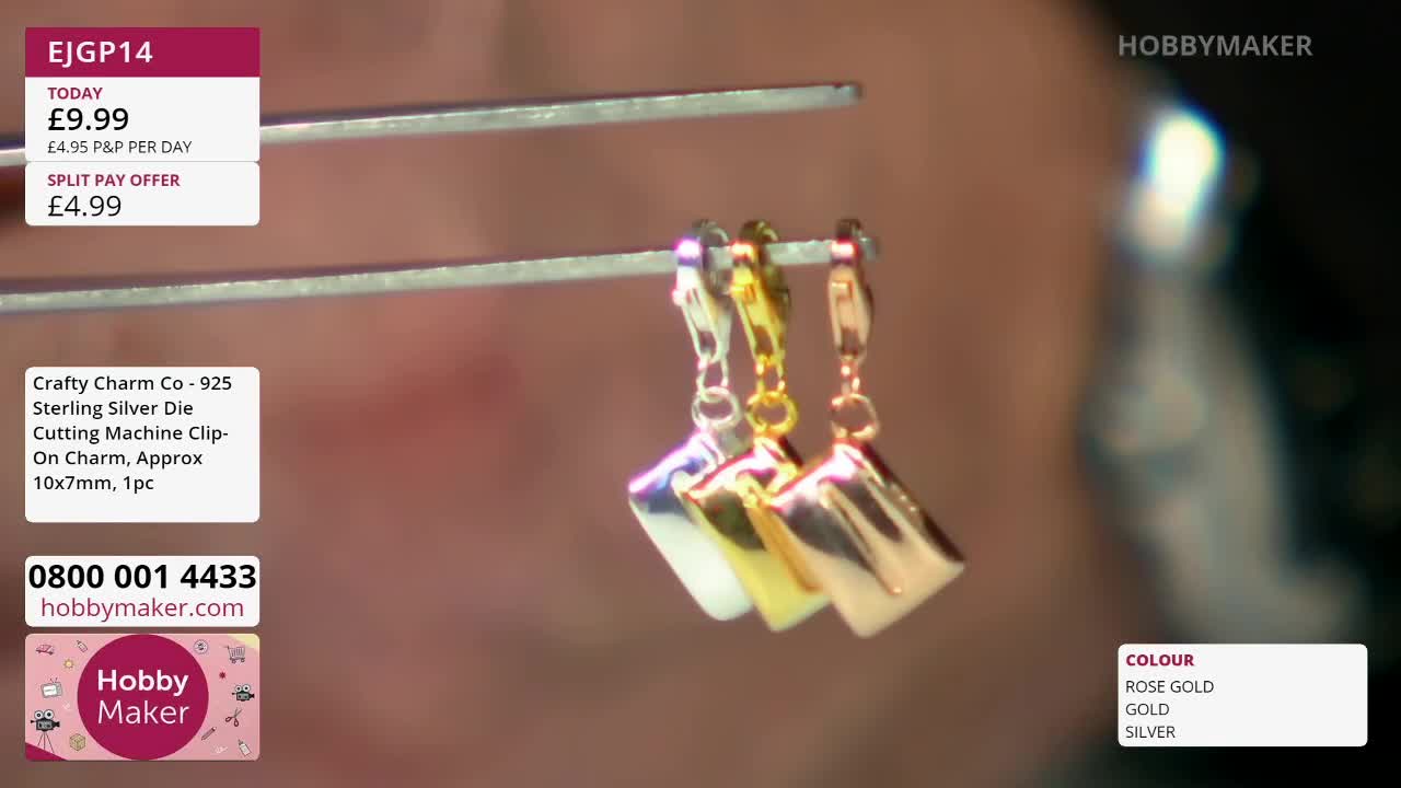 Three small charms, one silver, one gold, and one rose gold, dangle from a metal rod. They are being held by a pair of tweezers. Three small charms, one silver, one gold, and one rose gold, dangle from a metal rod. They are being held by a pair of tweezers.