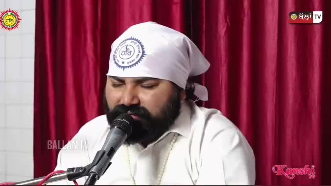 A man with a dark beard and a white turban speaks into a microphone. The Kanshi TV logo appears in the corner.