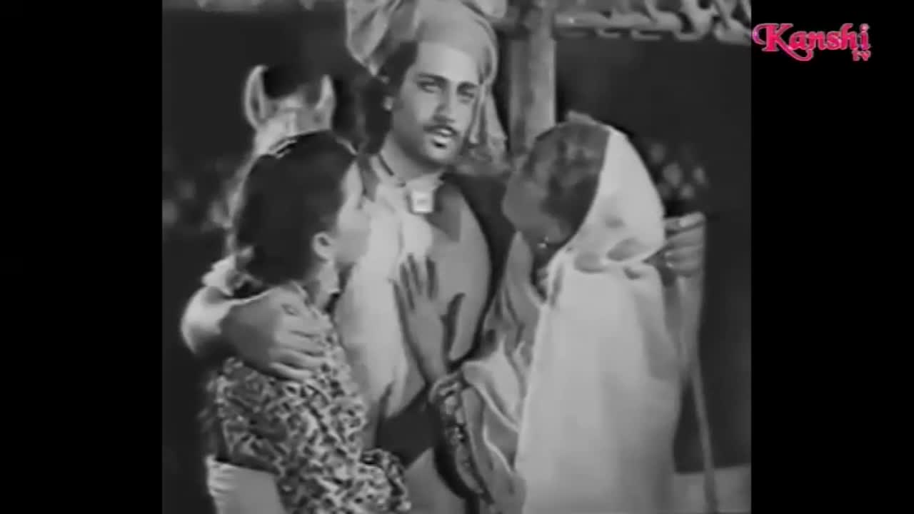 A man with a turban embraces a young girl and an older woman, his hand resting on the girl's shoulder. Their faces are turned towards each other in a moment of connection.
