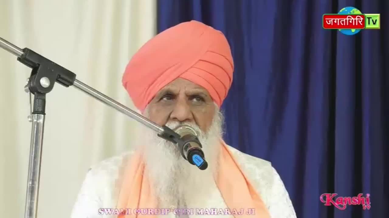 A man with a long white beard and an orange turban speaks into a microphone. The Kanshi TV logo is visible in the corner.