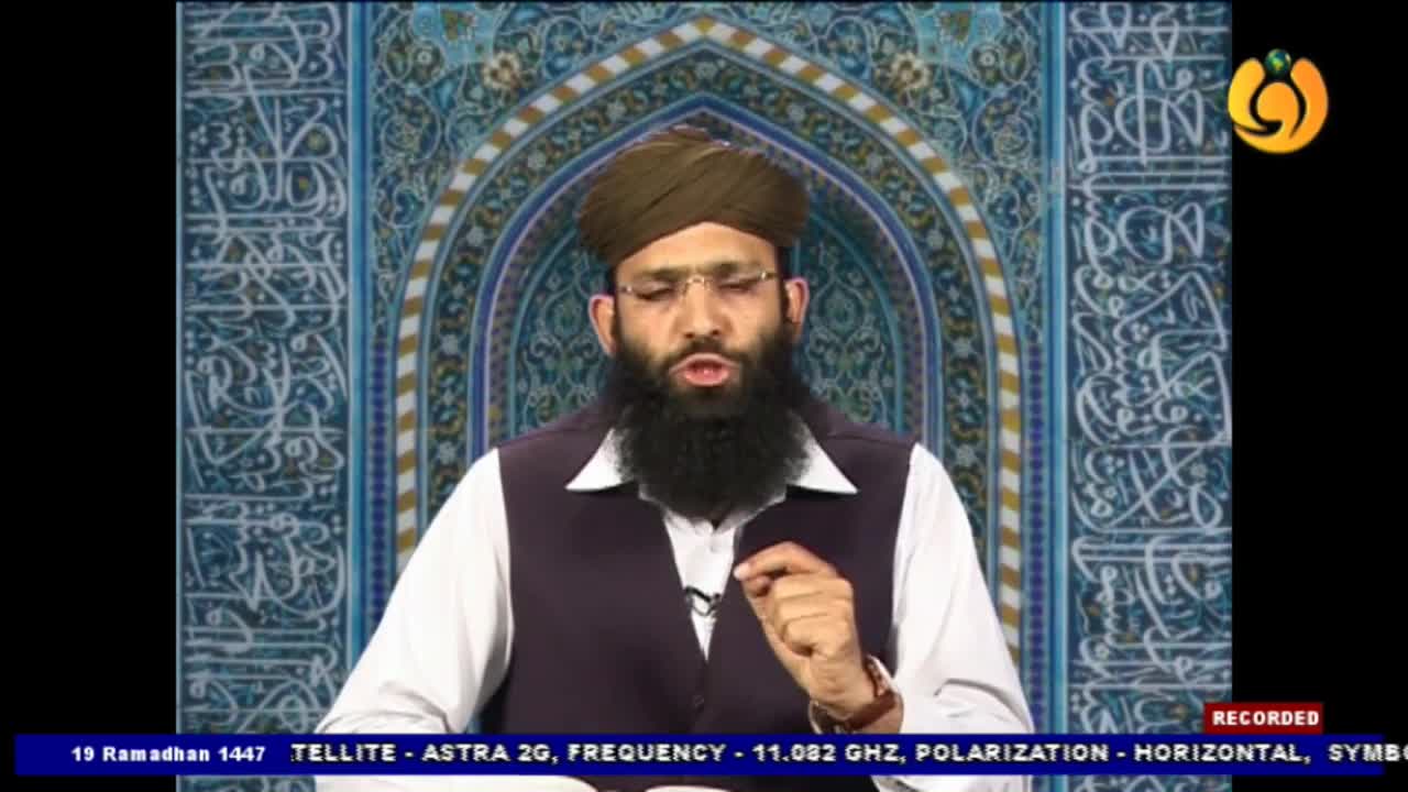 A man in a turban and vest speaks, gesturing with his right hand. The background behind him is decorated with intricate blue and gold Islamic calligraphy.