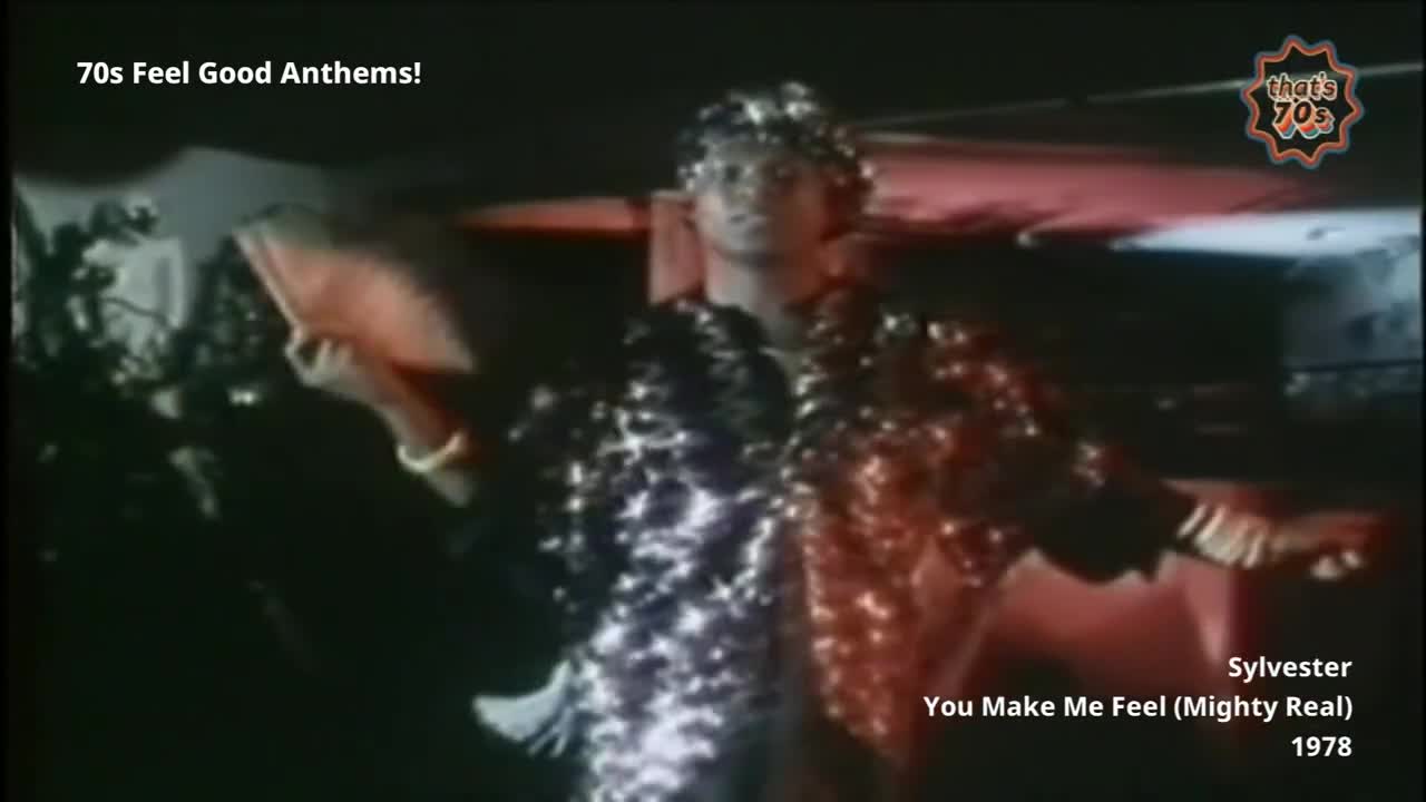 A performer in a shimmering, sequined jacket moves to the beat. He holds a book aloft, his arm extended as he sings.