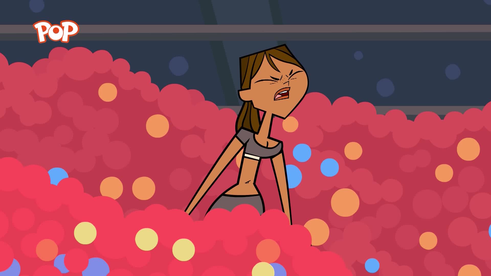 A young woman is struggling to get out of a pool filled with pink, bubbly foam and scattered blue and orange balls. The POP logo is visible in the top left corner.
