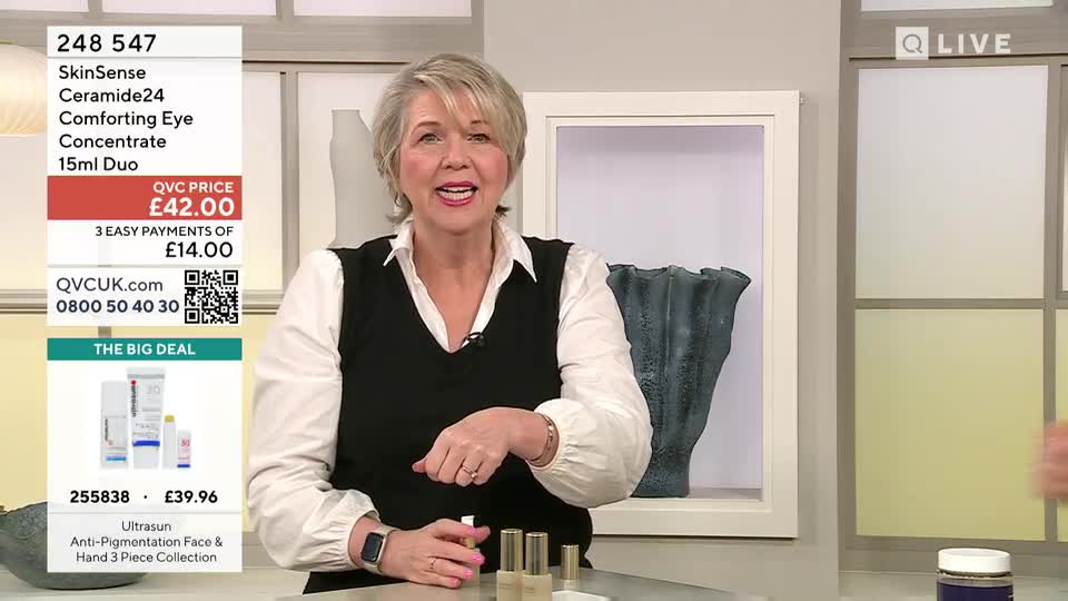 A woman on QVC UK holds up a small bottle, gesturing to three others lined up on the counter. The screen displays product details for a SkinSense concentrate.